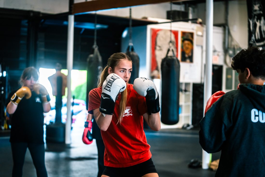 Coach throwing a punch demonstrating the mental and physical benefits of boxing